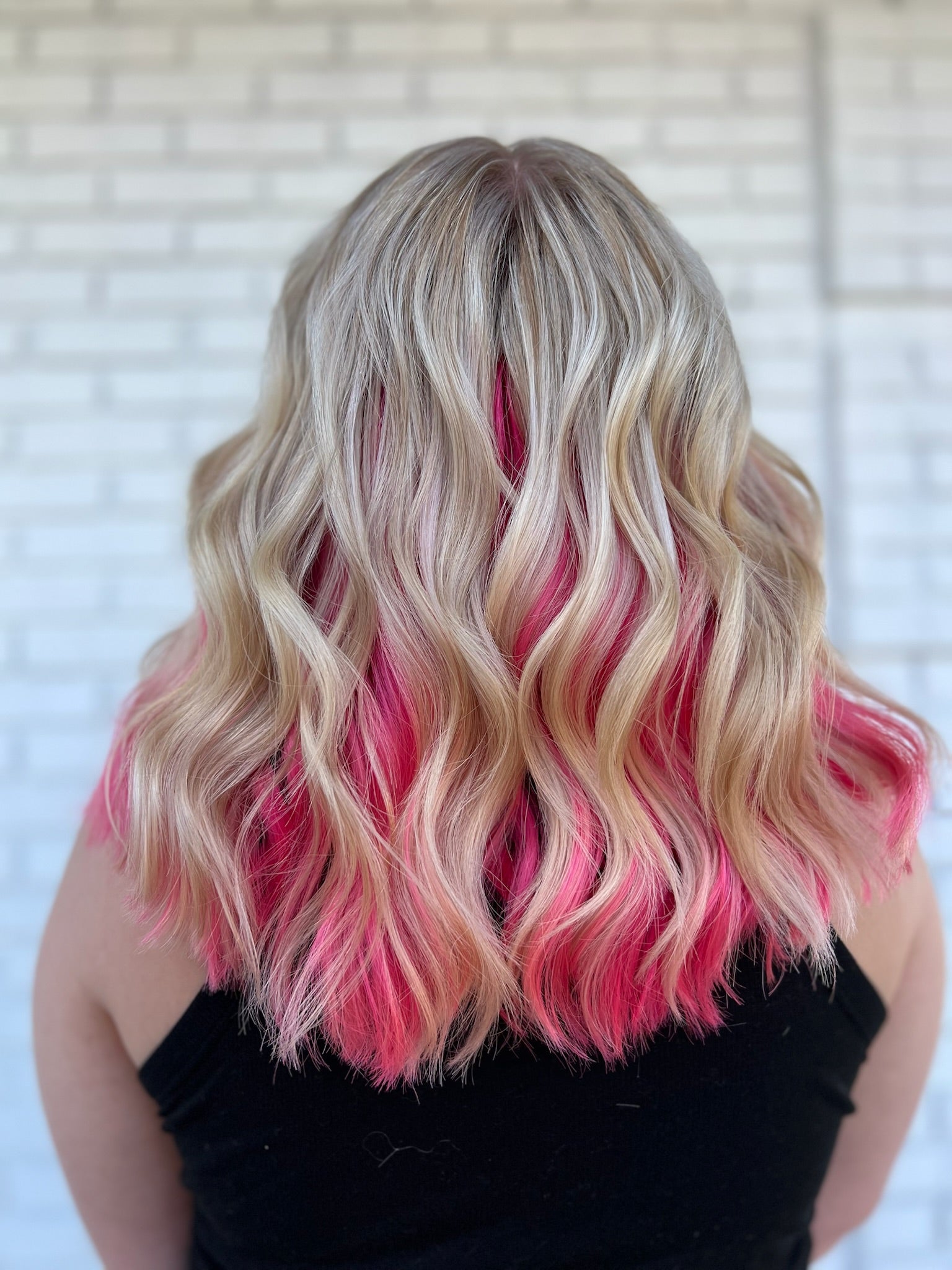 blonde wavy hair with pink colored hair on the underside
